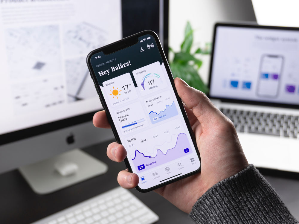 Hand holding a smartphone showing a banking app