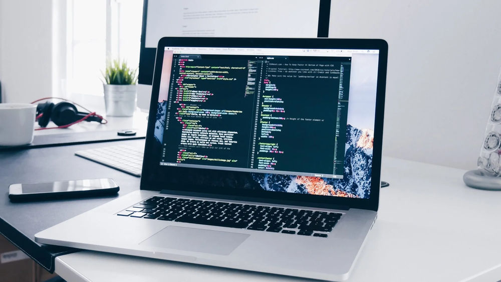 Laptop displaying code on a desk